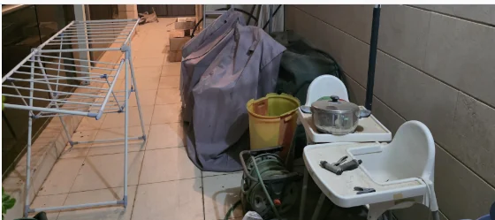 Balcony before decluttering with drying rack, household items and temporary objects occupying the walkway